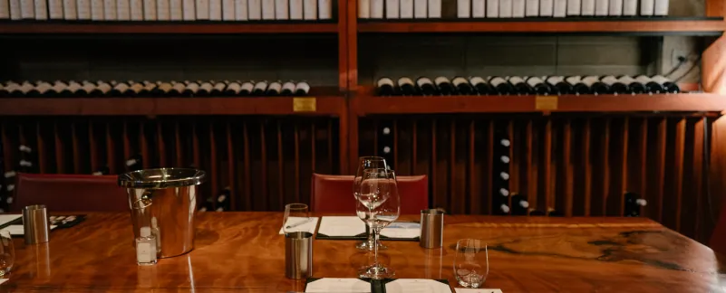 table with open menu and empty wine glasses